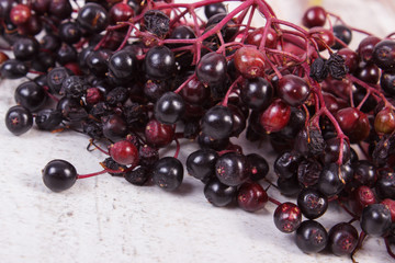 Bunch of fresh elderberry on old wooden background, healthy food