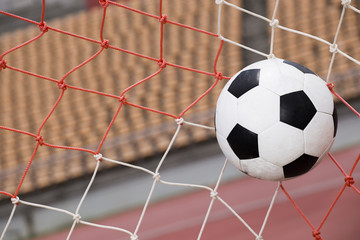 soccer ball in goal on stadium background