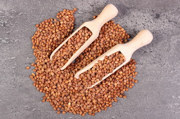 Buckwheat groats with spoon on cement structure