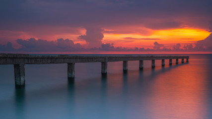 Fototapeta na wymiar Beautiful sunrise at the sea with stone bridge