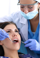 Woman dentist working at her patients teeth