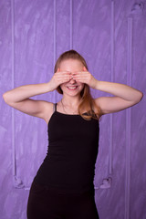 Fototapeta premium Portrait of young woman in a black closed her eyes with her hand