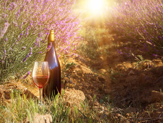 Obraz premium Bottle of wine against lavender landscape.