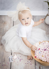 kleines m&auml;dchen mit torte zum 1. Geburtstag