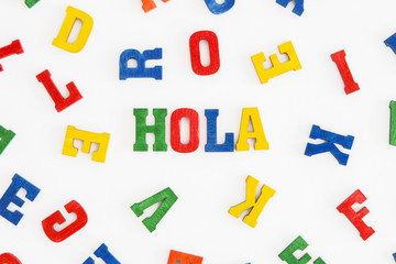 Series "Hello": word Hola (hello) in Spanish in wooden letters on white background   © Mellimage