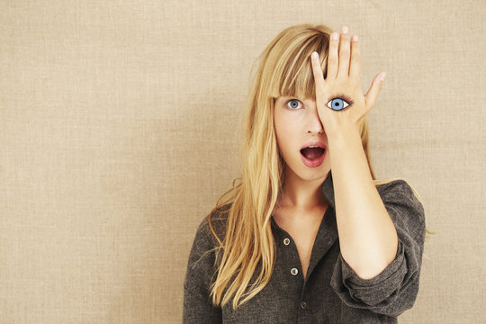 Shocked blond woman with painted eye