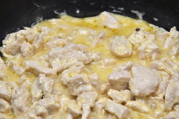 Background of hot sliced poultry boiling in cream sauce