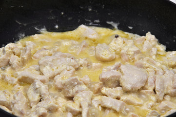 Background of hot sliced poultry boiling in cream sauce