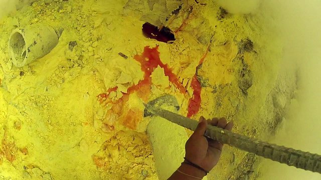 Sulfur miner extracting sulfur at Kawah Ijen volcano in East Java, Indonsia - GoPro POV.