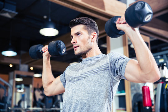 Man Workout With Dumbbells At Gym