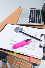 workplace with laptop and papers