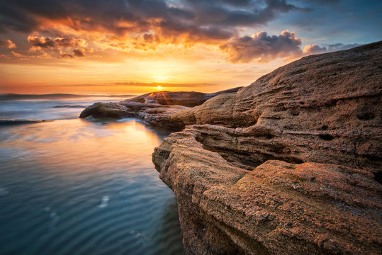 Fototapeta Rocky sunrise. Sea sunrise at the Black Sea coast near Ravda, Bulgaria