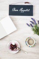 Cup of coffee with dessert and notebook on the table