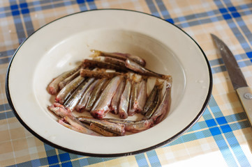 Cleaning and gutting little river fish
