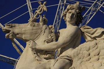 Horseman statue on the Place de la Concorde with ferris wheel at background, Paris, France