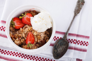 Crumble with strawberries, peach and a scoop of ice cream.selective focus