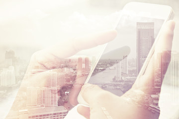 Plakat Using smart phone double exposure and cityscape background. Business technology concept.