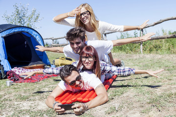 Fototapeta premium young boys and girls in campsite piled up smiling