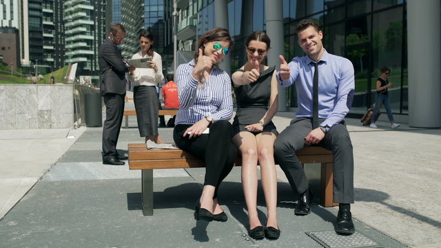 Businesspeople showing thumbs up to the camera, steadycam shot
