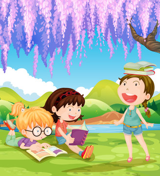 Children reading books under the tree