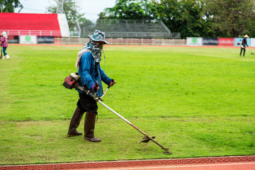  worker mowing the lawn at soccer stadium.