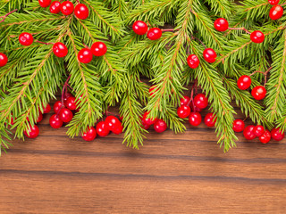 Christmas tree and red berries on the dark background