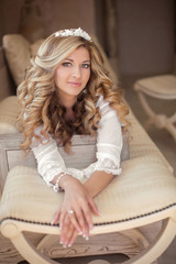 Portrait of beautiful smiling bride with long curly hair posing