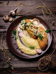 Cutlets with mashed potatoes on a wooden chopping board.