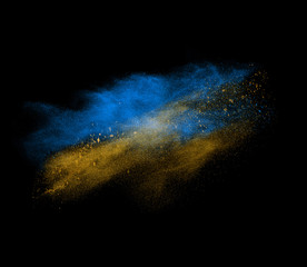 Blue and yellow powder explosion isolated on black 