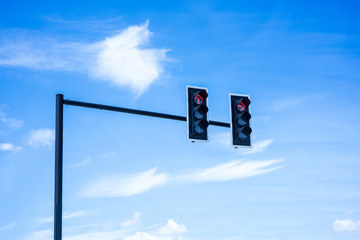 Red color on the traffic light with a beautiful blue sky in back