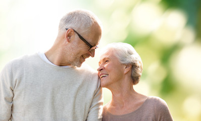 happy senior couple over green natural background