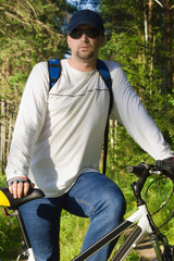 Obraz premium Handsome man biking in the countryside