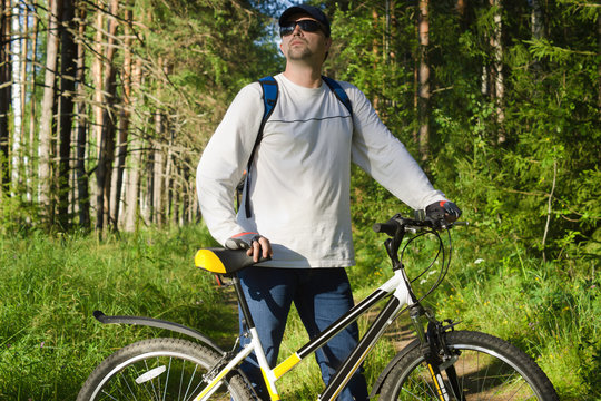 Handsome man biking in the countryside
