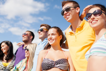 group of happy friends on beach