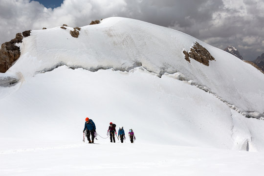 Trekking in Himalaya Hikers Walking Up on Glacier in Nepal India Himalaya Way up to high altitude famous attraction with Snow Climbing and trekking gear mountain sunny day Majestic Summit background © alexbrylovhk