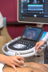 Closeup of man getting an ultrasound scan on abdominal by doctor