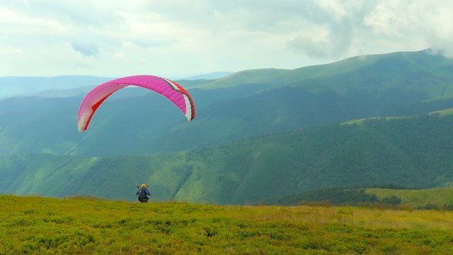 4k,
Paraglider flying high in the mountains