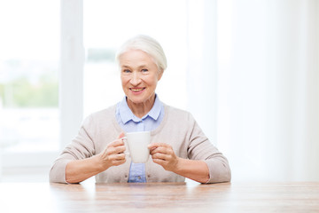 happy senior woman with cup of tea or coffee