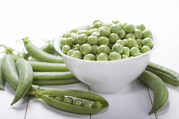 Fresh green peas in a white bowl  .