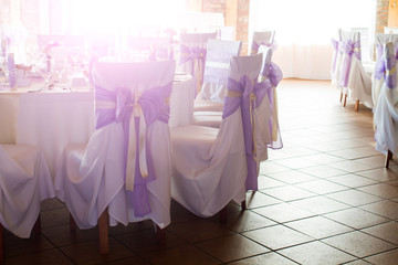 wedding or dinner table place setting, decorated chairs