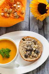 Healthy food - pumpkin vegetable soup and  bread with Chia seeds,  soy bean, pumpkin, pine and sunflower seeds