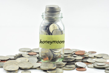 Isolated coins in jar with honeymoon label - financial concept