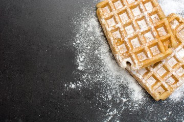 Waffles with sugar on slate table - obrazy, fototapety, plakaty