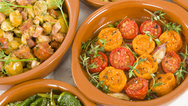 Spanish Tapas  - Tomates al Ajillo (Tomatoes with garlic), Pollo al limon con ajo (chicken with garlic) and Padron Peppers.
