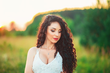 Naklejka premium beautiful young girl in a field in white dress and has long blac