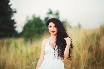 beautiful young woman in a field with a bouquet in hands