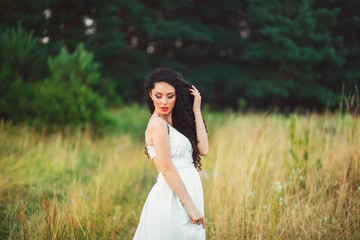 Fototapeta na wymiar beautiful girl in a white dress bouquet in hands