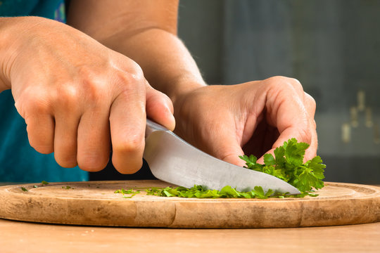hands chopping parsley leaves, closeup