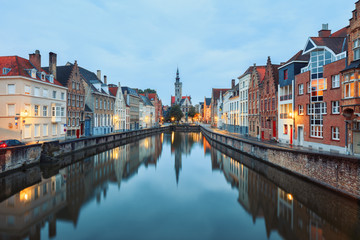 Fototapeta na wymiar Jan van Eyck Square over the waters of Spiegelrei, Bruges