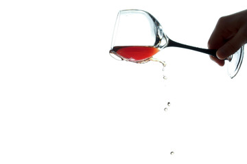 stream of wine being pouring down from the glass isolated on the white background
